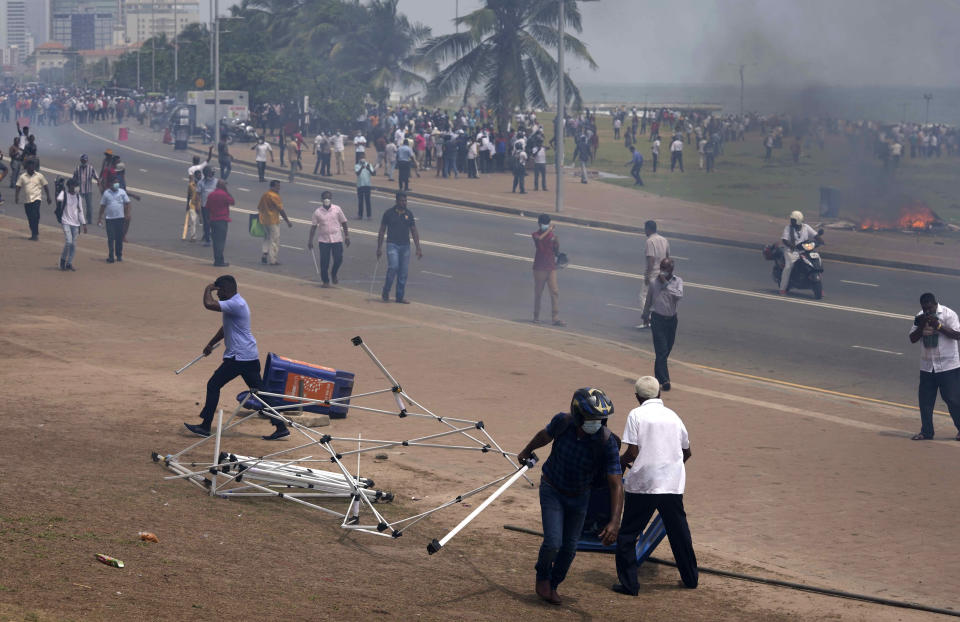 Sri Lankan government supporters vandalise anti government protest site outside the president's office in Colombo, Sri Lanka, Monday, May 9, 2022. Government supporters on Monday attacked protesters who have been camped outside the office of Sri Lanka's prime minster, as trade unions began a "Week of Protests" demanding the government change and its president to step down over the country's worst economic crisis in memory.(AP Photo/Eranga Jayawardena)