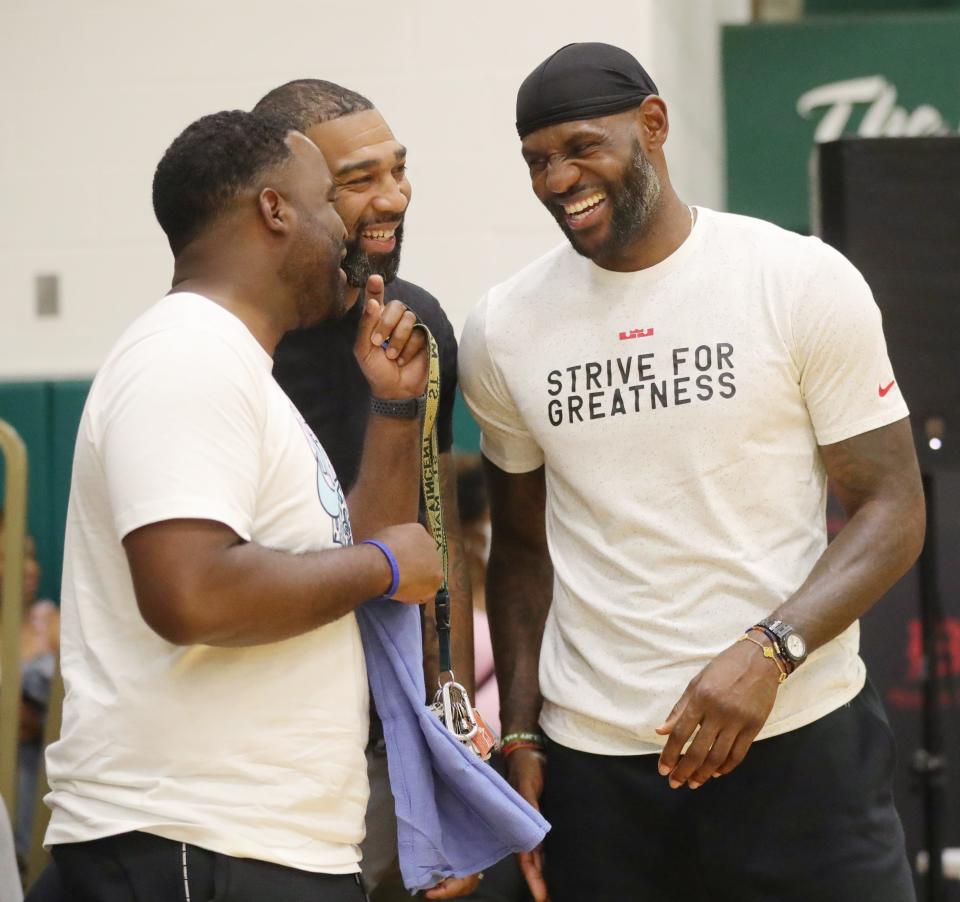 Former St. Vincent-St. Mary teammates Willie McGee, from left, Romeo Travis and LeBron James share a few laughs while watching Bronny James play basketball at LeBron James Arena in 2021 in Akron.