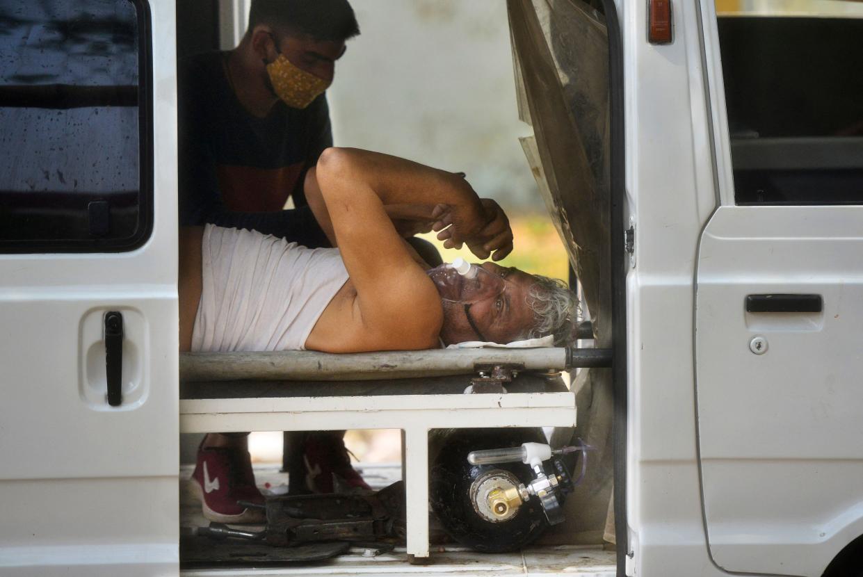 A Covid-19 coronavirus patient with breathing problems lays inside an ambulance while waiting to be admitted in a hospital in Allahabad on April 29, 2021.