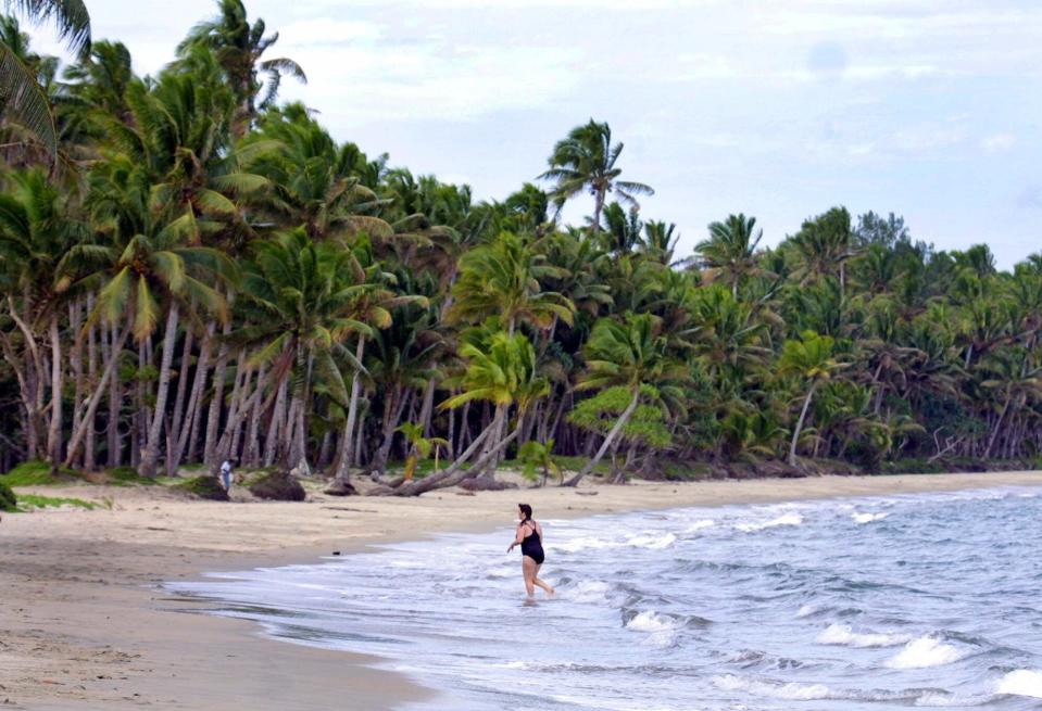 A tourist leaves the water after swimming at a beach near Suva, Fiji.