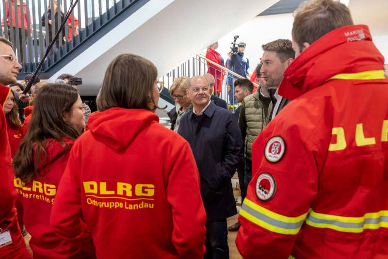 German Chancellor Olaf Scholz (C) visits with Anke Rehlinger, Minister President of the Saarland, the Saarbruecken stadium with the emergency services who were deployed to help with the Saar floods. Helmut Fricke/dpa
