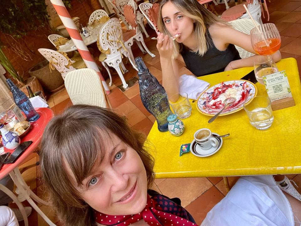 Two women seated at a yellow table in Madrid