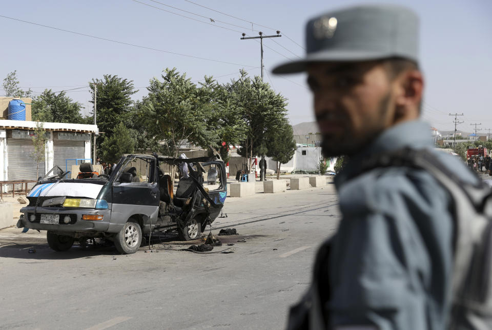 An Afghan security personnel inspect the site of a bomb explosion in Kabul, Afghanistan, Thursday, June 3, 2021. Police say a bomb has ripped through a minivan in the western part of the Afghan capital Kabul, killing at least four people. No one took responsibility for the attack in the neighborhood, which is largely populated by the minority Hazara ethnic group who are mostly Shiite Muslims. (AP Photo/Rahmat Gul)