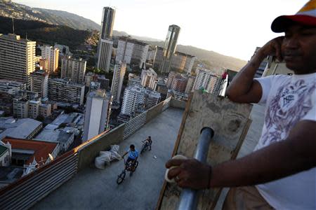 Children ride bicycles on one of the top inhabited floors of the "Tower of David" skyscraper in Caracas February 9, 2014. It boasts a helicopter landing pad, glorious views of the Avila mountain range, and large balconies for weekend barbecues. Yet a 45-storey skyscraper in the center of Venezuela's capital Caracas is no five-star hotel or swanky apartment block: it is a slum, probably the highest in the world. REUTERS/Jorge Silva