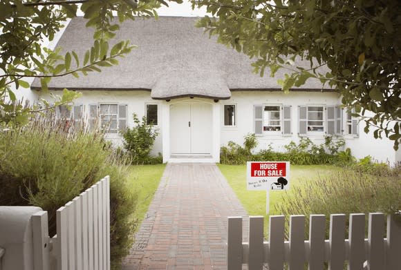 House with for-sale sign in front