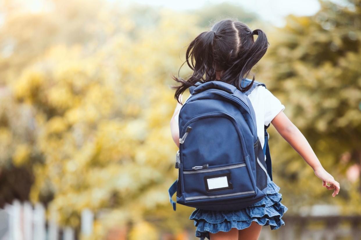 Back to school. Cute asian child girl with backpack running and going to school with fun