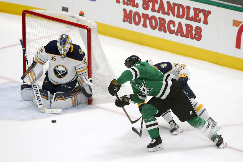 Buffalo Sabres goaltender Linus Ullmark, left, makes the save of the shot by Dallas Stars defenseman Roman Polak, right, as center Rasmus Asplund, obscured, defends during the second period of an NHL hockey game in Dallas, Thursday, Jan. 16, 2020. (AP Photo/Ray Carlin)