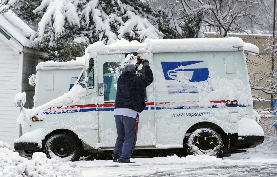 A letter carrier clears the snow from his vehicle outside the Pearl River Post Office.  Tuesday, February 28, 2023.