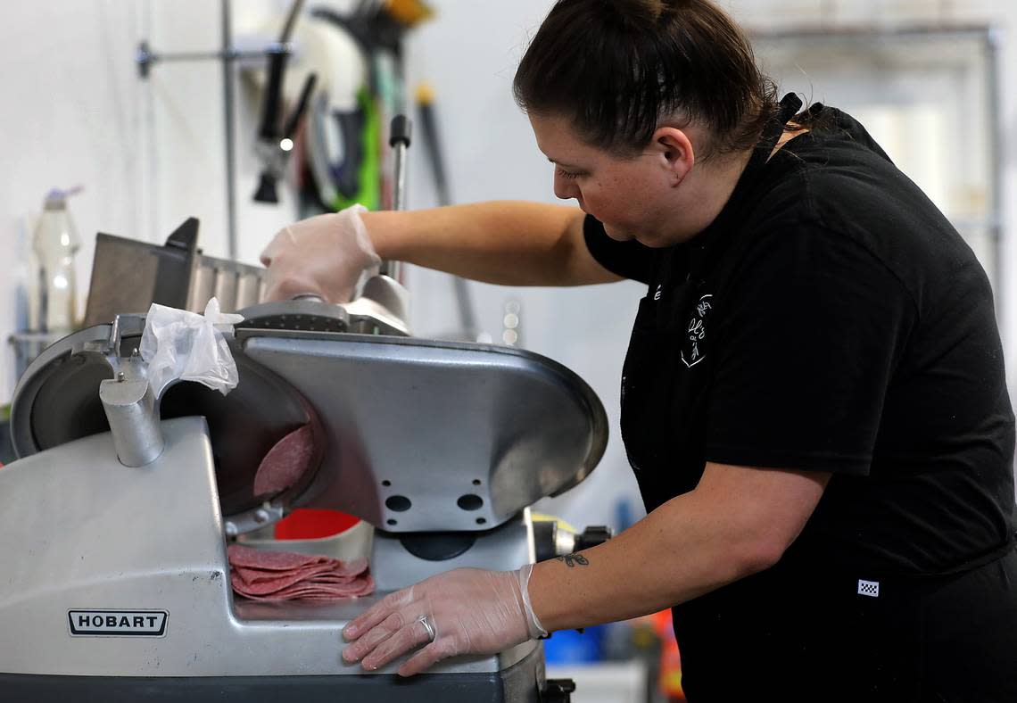 Jessie Schuh of Wild Olives Charcuterie Kingdom slices meat for an order in their new storement at 3306 N. Swallow Ave., on the industrial east side fo the Tri-Cities Airport in Pasco. Their business specializes in charcuterie and what it calls grazing boards that can serve 1-300 people.