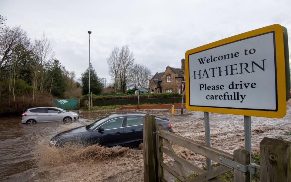 Motorists make their way through floodwater on Derby Road in Hathern, Leicestershire - Joe Giddens/PA