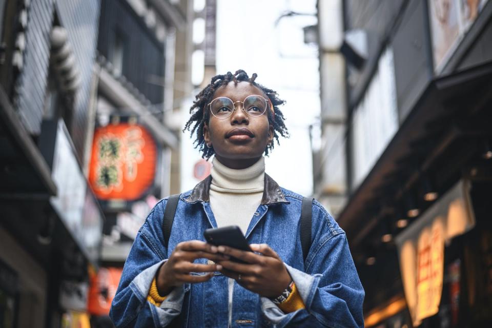 Black travelers want to see the travel industry embrace their full identities. <a href="https://www.gettyimages.com/detail/photo/african-woman-with-smartphone-vacationing-in-tokyo-royalty-free-image/1155295723?phrase=black+tourists&adppopup=true" rel="nofollow noopener" target="_blank" data-ylk="slk:AzmanL/ Getty;elm:context_link;itc:0;sec:content-canvas" class="link ">AzmanL/ Getty</a>