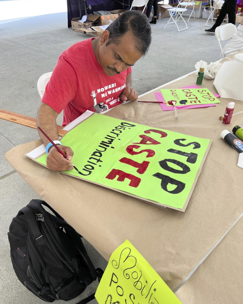 In this photo provided by Prem Pariyar, a Dalit Hindu from Nepal, he works on a banner at a People's Summit for Democracy event in Los Angeles in June 2022. Pariyar gets emotional as he talks about escaping caste violence in his native village. His family was brutally attacked for taking water from a community tap, said Pariyar, who is now a social worker in California and serves on Alameda County's Human Relations Commission. He moved to the U.S. in 2015, but says he couldn't escape stereotyping and discrimination because of his caste-identifying last name, even as he tried to make a new life thousands of miles away from home. (Courtesy of Prem Pariyar)