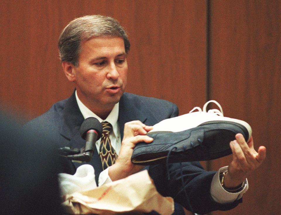 FBI agent William Bodziak testifies while holding one of O.J. Simpson's white tennis shoes, comparing it with a sample Bruno Magli shoe in a size comparable to Simpson's, during testimony on shoeprints found at the Bundy Drive murder scene in the O.J. Simpson double-murder trial Monday, June 19, 1995 in Los Angeles. 
