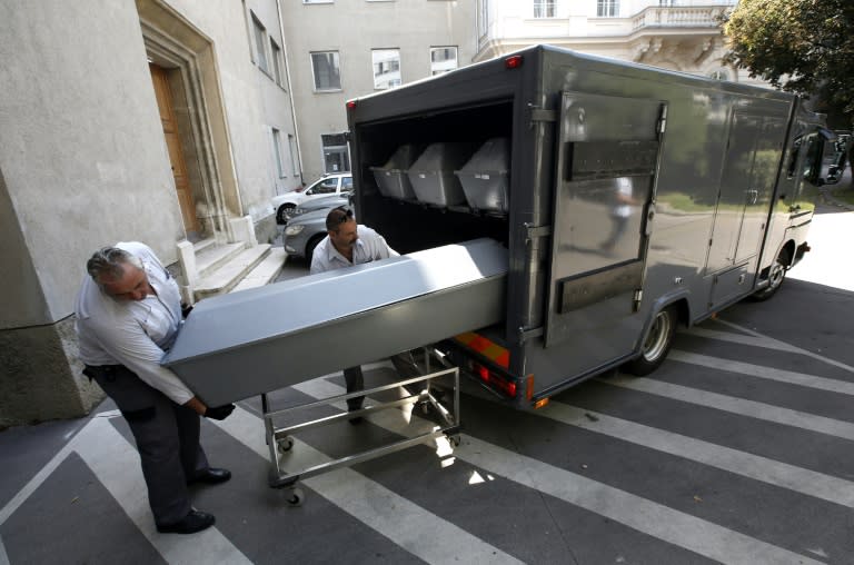 Coffins with bodies of migrants who died in an abandoned lorry are unloaded from a van on August 28, 2015 in Vienna