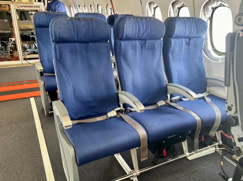 Rows of blue passenger seats on the 777X.