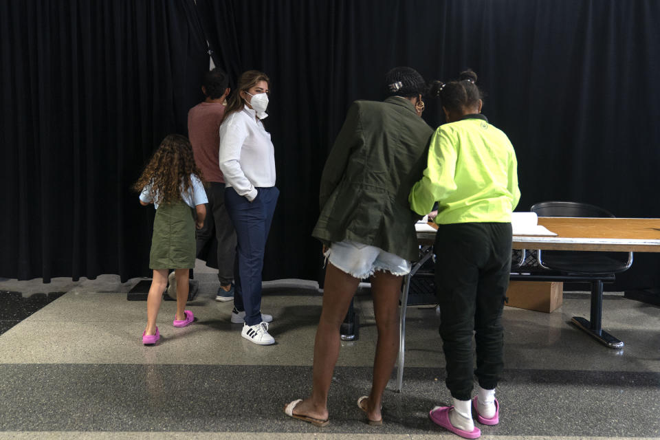 Migrants check in and out of a makeshift shelter at O'Hare International Airport run by a private firm hired by the city, Wednesday, Sept. 20, 2023, in Chicago. Unlike migrants in the public eye at police stations, the migrants at O'Hare and a handful at Midway International Airport have limited access to resources, including showers and medical care. (AP Photo/Erin Hooley)