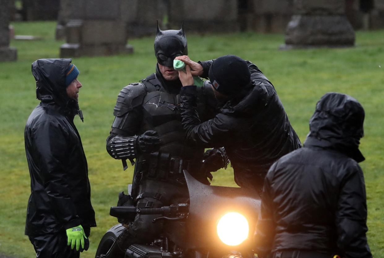 A man dressed as Batman has his face wiped during filming at the Glasgow Necropolis, February 2020. (Andrew Milligan/PA Images via Getty Images)