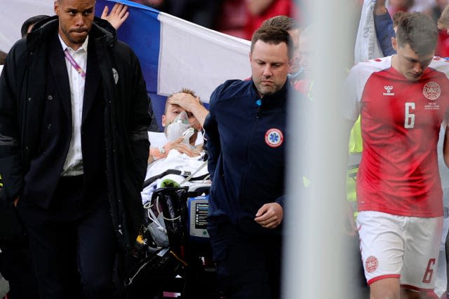 Paramedics using a stretcher to take Denmark’s Christian Eriksen off the pitch after he collapsed