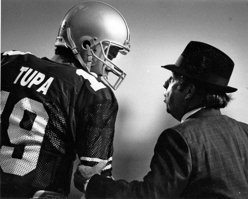 Black and white file photo of Earle Bruce (right) talking to Tom Tupa in 1987 (Columbus Dispatch Photo by Tim Revell).