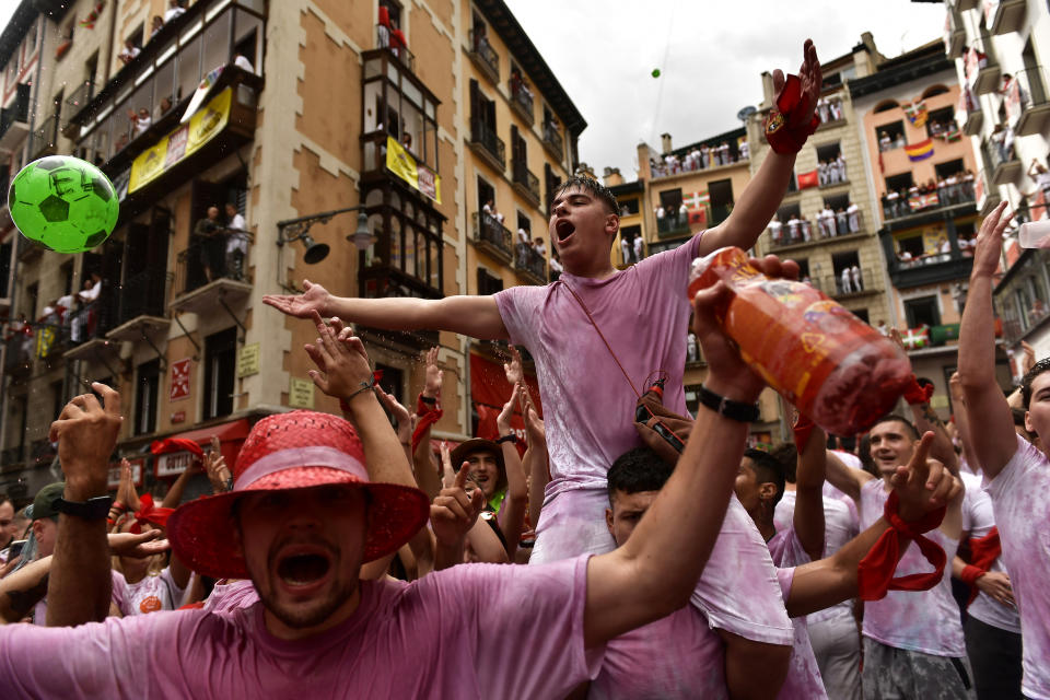 Revelers celebrate while waiting for the launch of the 'Chupinazo' rocket, to mark the official opening of the 2022 San Fermin fiestas in Pamplona, Spain, Wednesday, July 6, 2022. The blast of a traditional firework opens Wednesday nine days of uninterrupted partying in Pamplona's famed running-of-the-bulls festival which was suspended for the past two years because of the coronavirus pandemic. (AP Photo/Alvaro Barrientos)