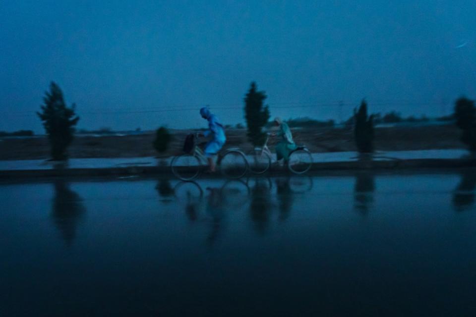 Cyclists pedal through a downpour in Kandahar, Afghanistan on May 3, 2021.