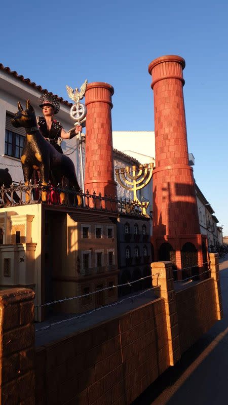 A woman is seen standing on a carnival float depicting Third Reich eagle symbol, Menorah candle holder and crematorium chimneys, during a carnival parade in Campo de Criptana