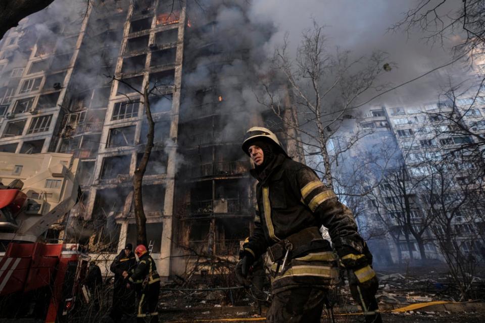 A firefighter walks below a shelled building in Kyiv, Ukraine, on 15 March, 2022. (AP)