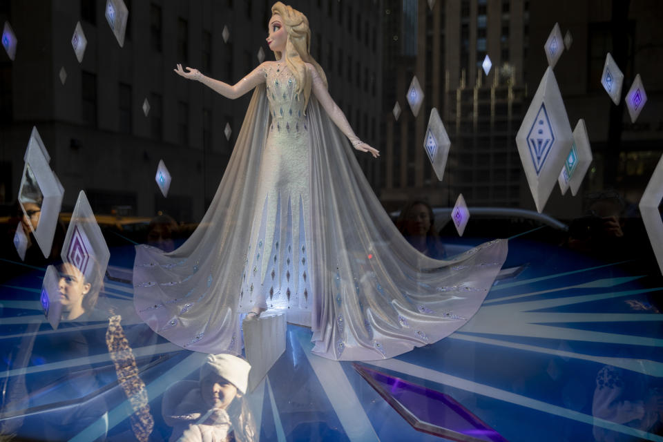 In this Tuesday, Nov. 26, 2019, photo shows a couple of young girls inspecting the Frozen-themed holiday window at the Saks Fifth Avenue Flagship in New York. Luxury department stores like Neiman Marcus and Saks Fifth Avenue once ruled among the affluent set. Now, they’re fighting a tough battle to lure younger shoppers faced with a lot more shopping choices, including second-hand retailers and fashion rental companies. (AP Photo/Mary Altaffer)