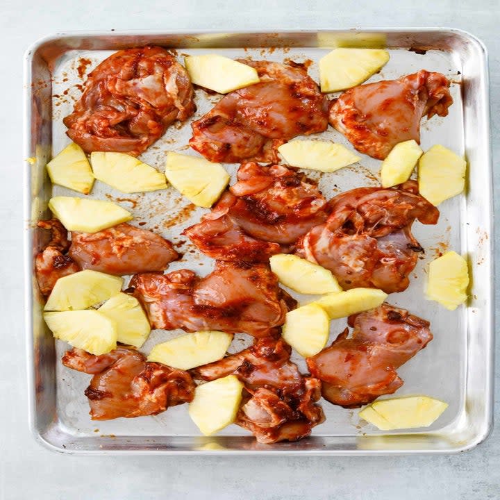 Marinated chicken and pineapple on a baking sheet