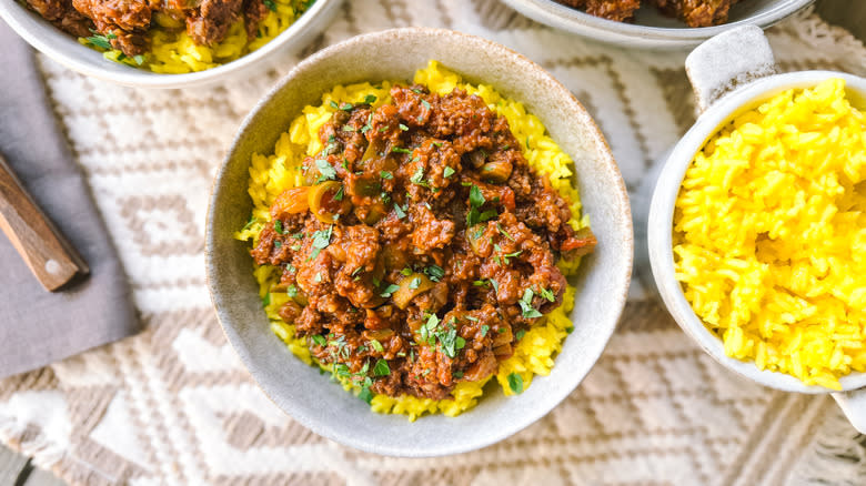 Picadillo with saffron rice in bowls on table