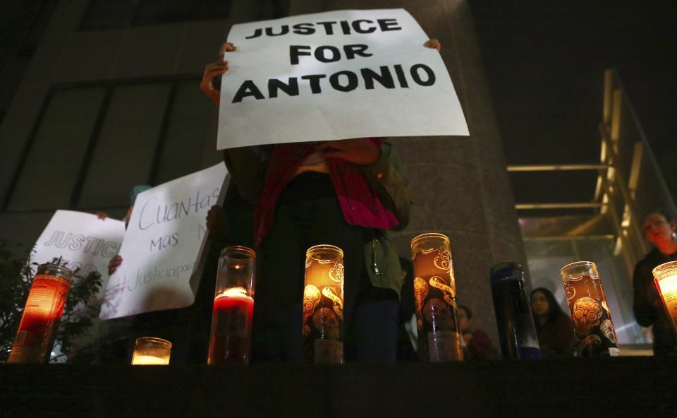 Family members and others stand in front of the Tempe Police headquarters to hold a protest and vigil for a 14-year-old boy who was shot to death by Tempe Police on Tuesday, as police say they were pursuing a burglary suspect who they thought had a handgun, Thursday, Jan. 17, 2019, in Tempe, Ariz. It turns out, according to police, the teen had a replica gun. (AP Photo/Ross D. Franklin)