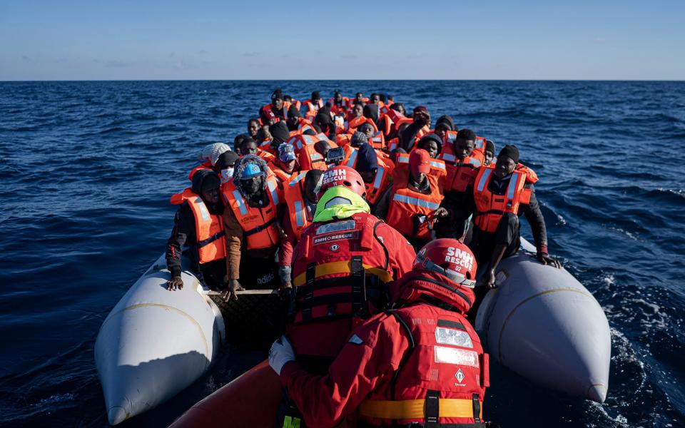 Migrants and refugees from Africa sailing adrift on an overcrowded rubber boat, are assisted by aid workers of the Spanish NGO Aita Mary in the Mediterranean Sea, about 103 miles from the Libyan coast in January 2022