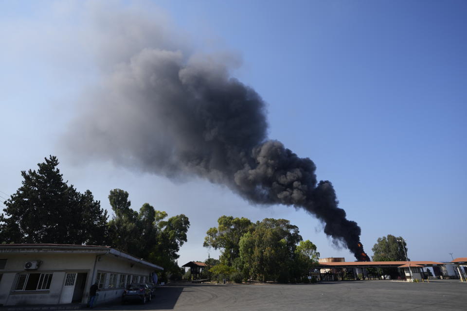 Firefighters work to extinguish a fire in an oil facility in the southern town of Zahrani, south of the port city of Sidon, Lebanon, Monday, Oct. 11, 2021. A huge fire broke out at an oil facility in southern Lebanon's coastal town of Zahrani, but the cause was not immediately known. (AP Photo/Hassan Ammar)