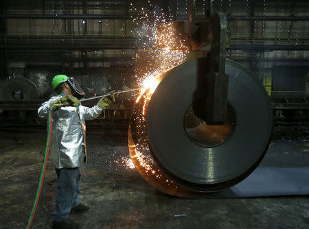 A worker cuts a piece from a steel coil at the Novolipetsk Steel PAO steel mill in Farrell, Pennsylvania, U.S., March 9, 2018. REUTERS/Aaron Josefczyk