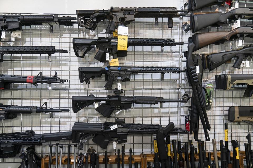 AR-15-style guns hang on a store wall in Burbank, Calif. Authorities say the shooter at Old National Bank in Louisville, Ky., legally purchased a similar rifle from a local gun dealer a week prior to the shooting.