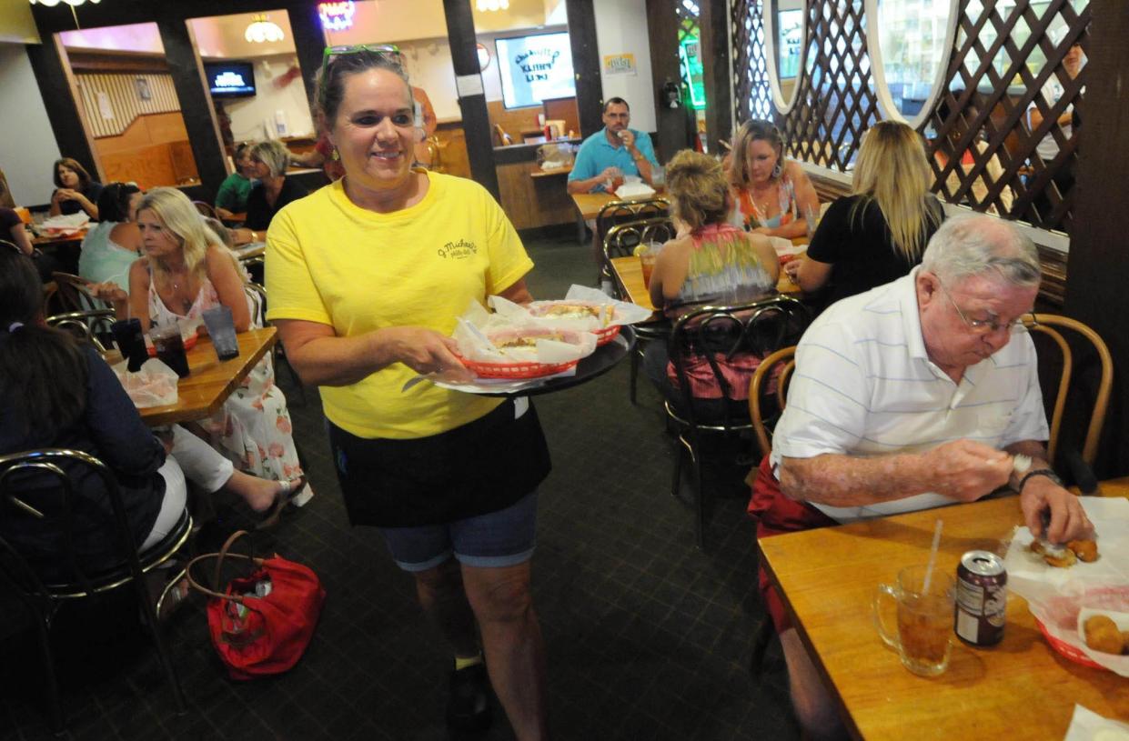 Long-time server Merry Futch brings food to a table at J. Michael's Philly Deli in Wilmington the local restaurant was started in 1979. MATT BORN/STARNEWS