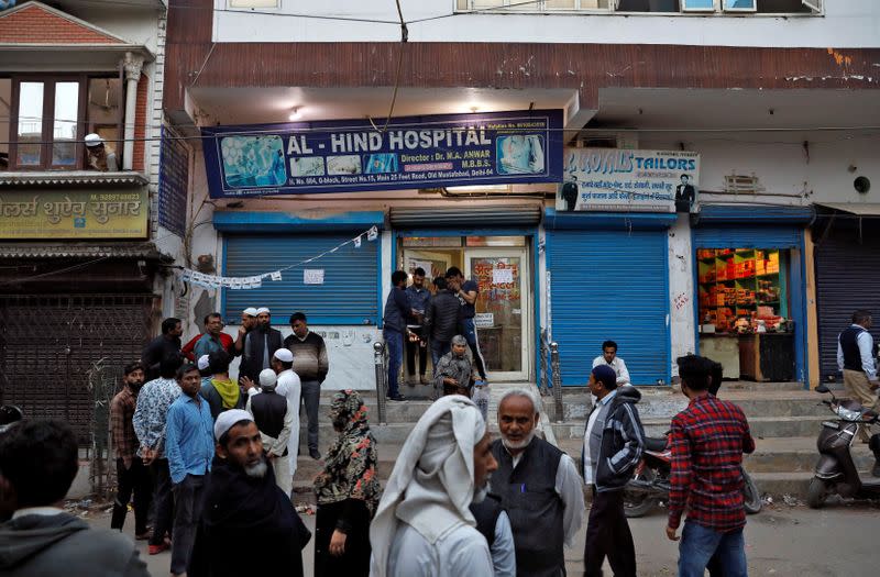 People gather outside the Al Hind hospital, where victims are treated and many have taken shelter after they fled their homes following clashes between people demonstrating for and against a new citizenship law in a riot affected area in New Delhi