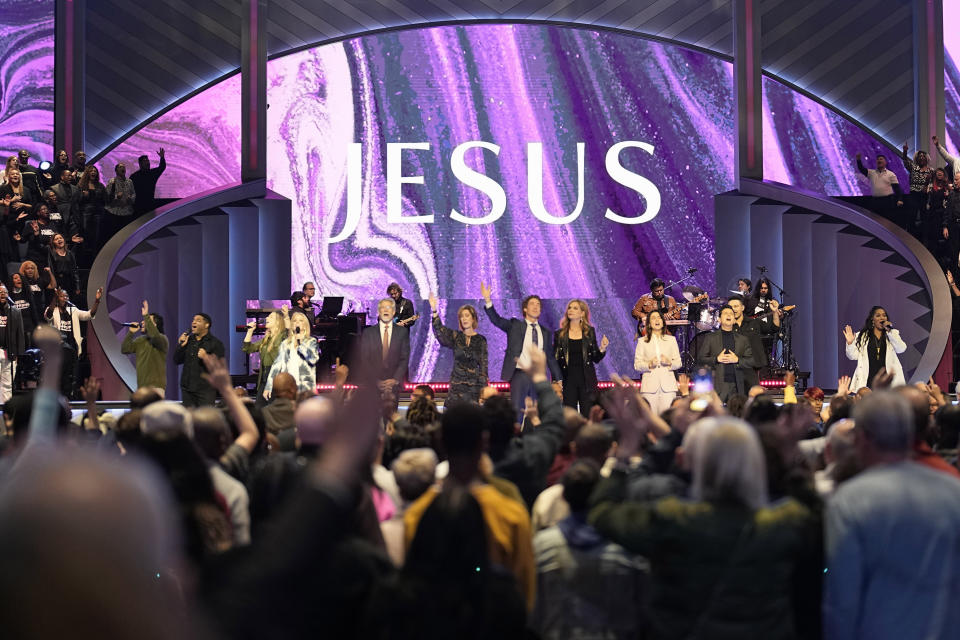 Pastor Joel Osteen leads the congregation in prayer during a service at Lakewood Church Sunday, Feb. 18, 2024, in Houston. Pastor Osteen welcomed worshippers back to Lakewood Church for the first time since a woman with an AR-style opened fire in between services at his Texas megachurch last Sunday. (AP Photo/David J. Phillip)