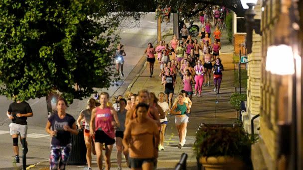PHOTO: Runners head down the sidewalk past Fountain Square on Georgia Avenue during 'Finish Eliza's Run,' Sept. 9, 2022 in Chattanooga, Tenn.   (Chattanooga Times Free Press via AP)
