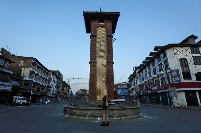 An Indian Central Reserve Police Force officer stands guard at an empty square during a lockdown on the first anniversary of the revocation of Kashmir's autonomy in Srinagar