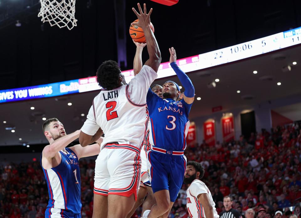 Kansas basketball's Dajuan Harris Jr. (3) shoots the ball as Houston center Cedric Lath (2) defends during the first half Saturday in Houston.