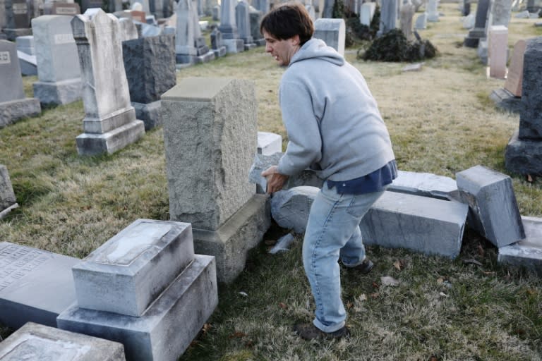 A man replaces a broken piece of a tombstone at the Jewish Mount Carmel Cemetery, February 26, 2017, in Philadelphia, PA