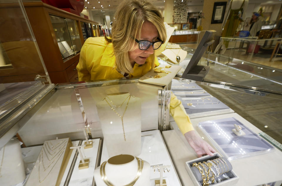 Frannie Harder adjusts the display of Monica Rich Kosann jewelry at the Neiman Marcus department store in NorthPark shopping center in Dallas, Thursday, March 30, 2023. Wealthier shoppers are still spending freely even in the face of higher inflation and a volatile economic environment. Luxury retailer Neiman Marcus is doubling down on catering to its high end shoppers.(AP Photo/LM Otero)