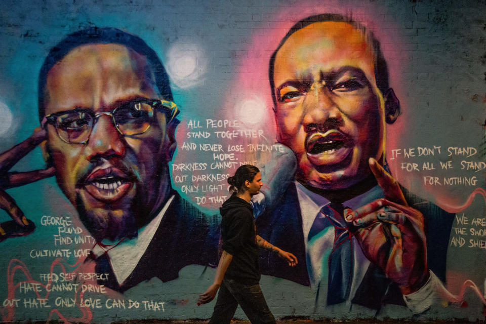 A man walks past a mural of Malcom X and Martin Luther King paying tribute to George Floyd, a Black man who died in police custody in the U.S. Artists have been painting murals and sharing messages in London. (Photo by Thabo Jaiyesimi / SOPA Images/Sipa USA)