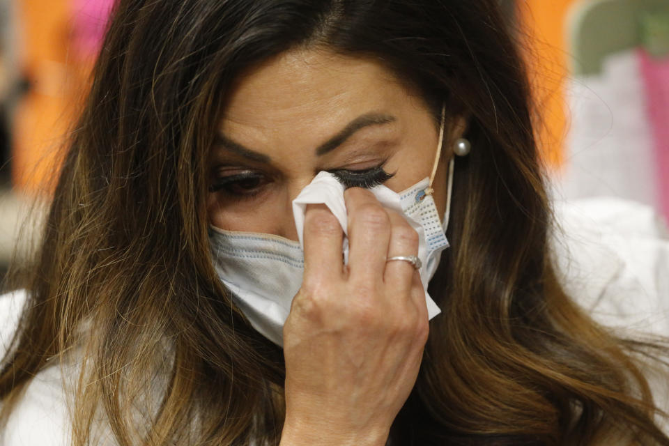 In this May 11, 2020, photo, health investigator Maria DiCaro grabs a facial tissue to wipe her eyes after chatting by phone with a person who had been exposed to somebody else who tested positive for the coronavirus at her office at the Salt Lake County Health Department, in Salt Lake City. The contact tracers often find themselves in a tangled web of half-truths and fact that don't match up. Language and cultural barriers arise that require interpreters and taxing conversations that leave the contact tracers wondering if the person understands what they're trying to do. (AP Photo/Rick Bowmer)