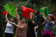 Members of an informal plaza dance group wave cloth fans as they dance to music at a public park in Beijing, Tuesday, Sept. 28, 2021. Plaza dance, group dancing performed in public spaces like parks or squares, is a popular activity in China particularly with middle-aged and older women that was briefly curtailed at the height of the COVID-19 pandemic. Its popularity has returned as China has lifted many restrictions on daily life amid a largely successful battle to control the local spread of coronavirus. (AP Photo/Mark Schiefelbein)