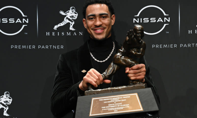 Alabama's Bryce Young holds up the Heisman Trophy.