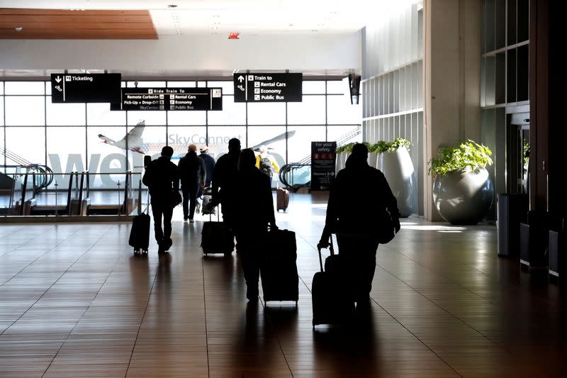 Airline passengers walk inside the Tampa International Airport