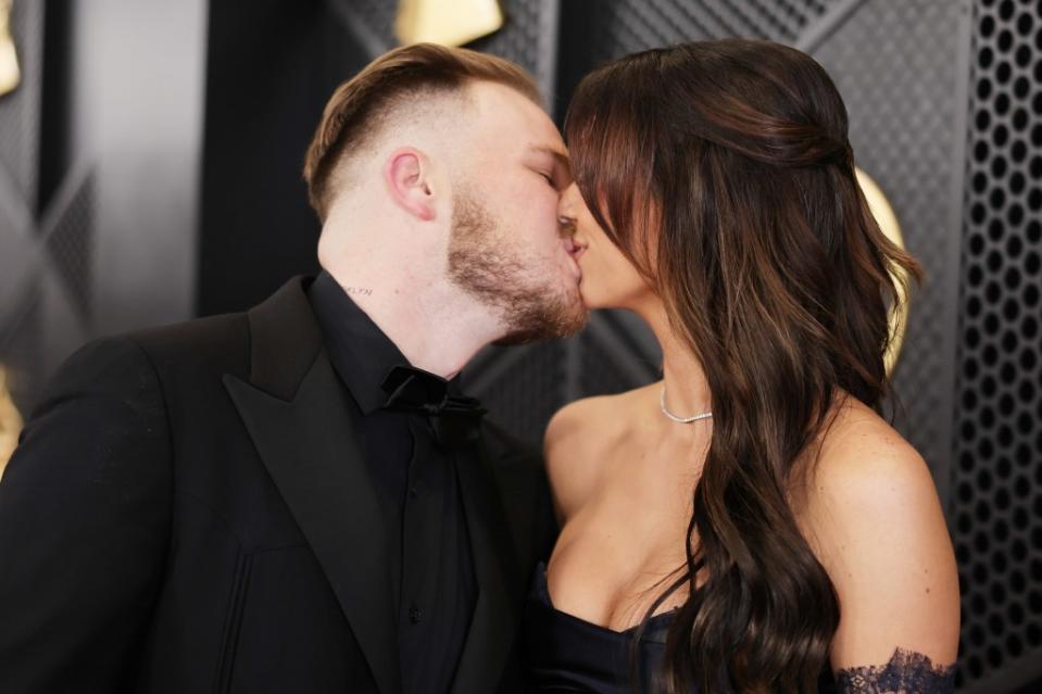 Zach Bryan and Brianna Chickenfry kiss at the 2024 Grammy Awards. Getty Images for The Recording Academy