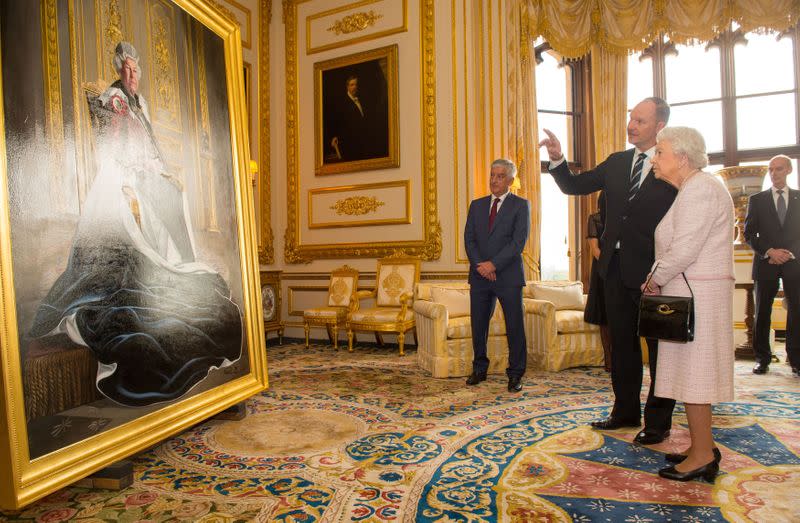 FILE PHOTO: British artist Henry Ward shows Britain's Queen Elizabeth his portrait of her, which was commissioned to mark her six decades of patronage to the British Red Cross, at Windsor Castle